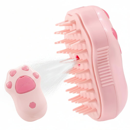Pink pet grooming brush with USB cable, held by a hand, and used on a cat.